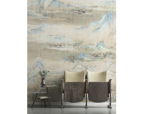 Rum med mönstrad tapet, två stolar och ett litet bord