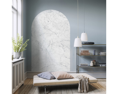 Vardagsrum med bågformad väggmålning i marmorlook, schäslong och hyllor