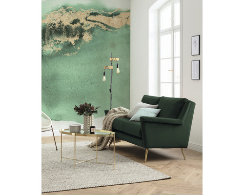 Ljust vardagsrum med grön soffa, soffbord och mönstrad tapet