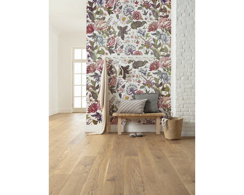 Ljust rum med blommig tapet, trägolv, sittbänk och dekorationer.