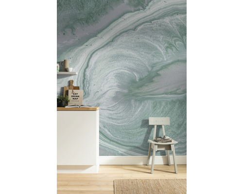 Vardagsrum med mönstrad tapet, stol och kökselement