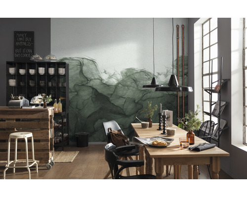 Miljöbild med matbord, stolar, hylla och dekoration framför en vägg med abstrakt tapet.