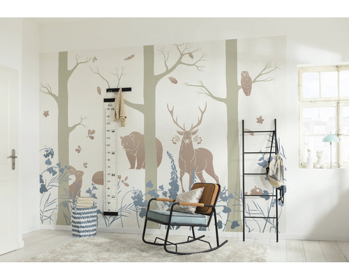 Barnrum med skogsdjursmotiv på väggen, en svart hylla, en gungstol och en mätsticka.