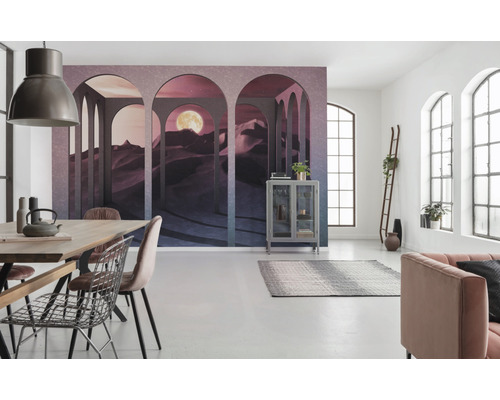 Ljust rum med fotovägg öken med måne, matbord, stolar, vitrinskåp och soffa.