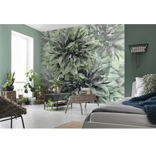Vardagsrum med geometrisk blomstertapet, säng och växter