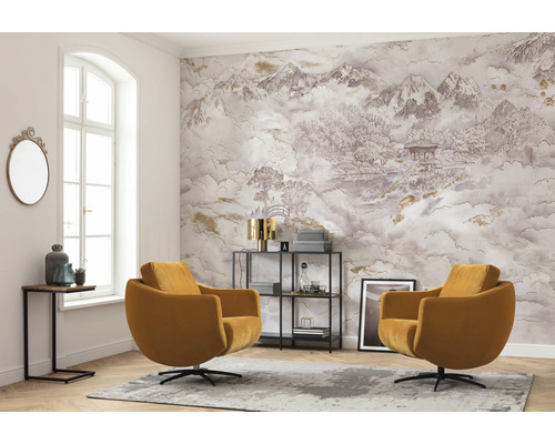 Vardagsrum med två fåtöljer, väggtapet med bergslandskap och dekorationer