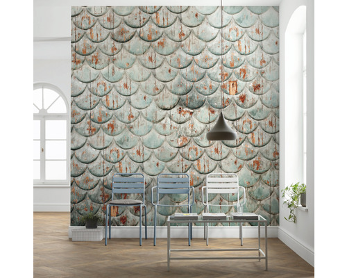 Dekorativ interiör med väggtapet i fiskfjällsmönster, stolar och sidobord.