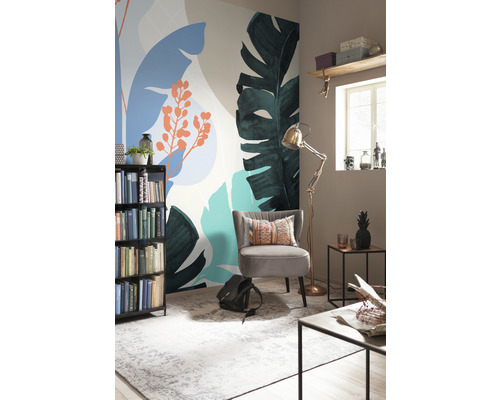 Dekorativt rum med fototapet med växtmotiv, fåtölj, bokhylla och golvlampa