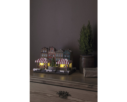 Julmarknadsby med belysning och dekorativa hus på ett bord