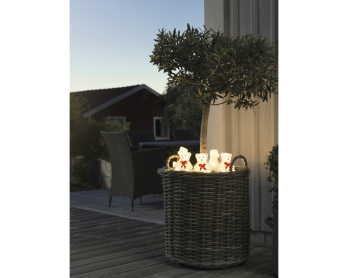 Dekorativ flätad korg med nallebjörnar utomhus.