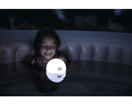 En flicka håller en lysande sfär i en bubbelpool