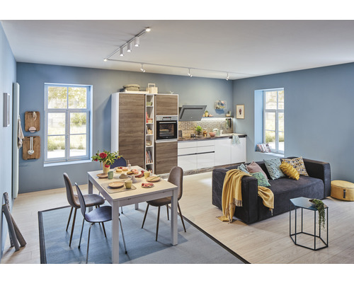 Ljust vardagsrum med integrerat kök, matbord och soffa