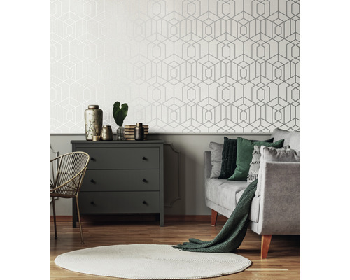 Vardagsrum med geometrisk tapet, byrå och soffa