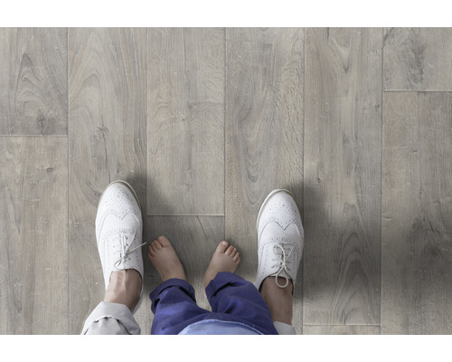 Golv med laminat i träutseende och personfötter