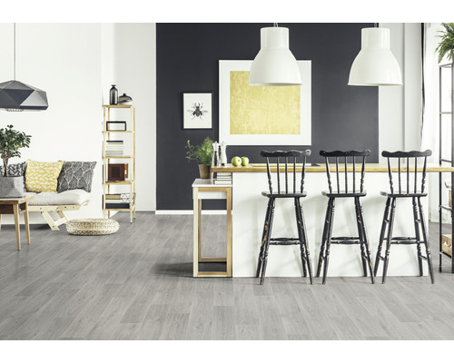 Ljust rum med grått trägolv, barstolar och hyllor.