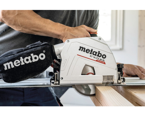 Metabo logotyp. Man använder en Metabo batteridriven cirkelsåg KT 18 LTX 66 BL vid sågning av en träbit.