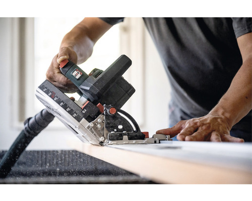 Man som sågar trä med en sänksåg