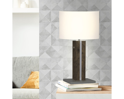 Bordslampa med träfot och lampskärm på böcker