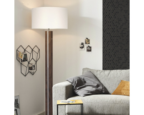 Vardagsrum med golvlampa, soffa och väggdekoration