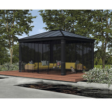 Paviljong med möbler på en träterrass i en trädgård.
