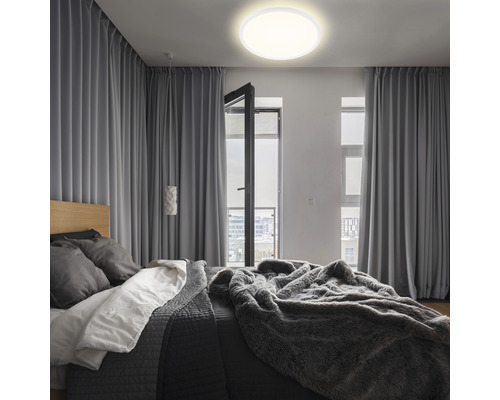 Sovrum med säng, gardiner och rund taklampa