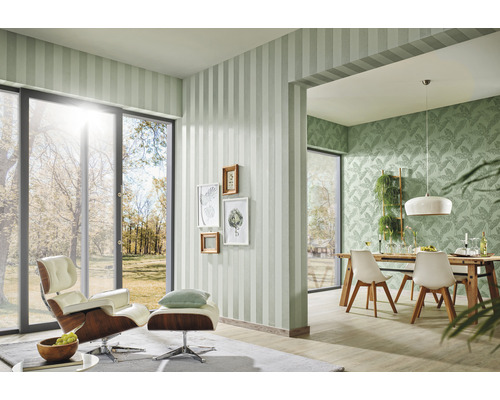 Vardagsrum med randig tapet, fåtölj och matbord för en ljus atmosfär