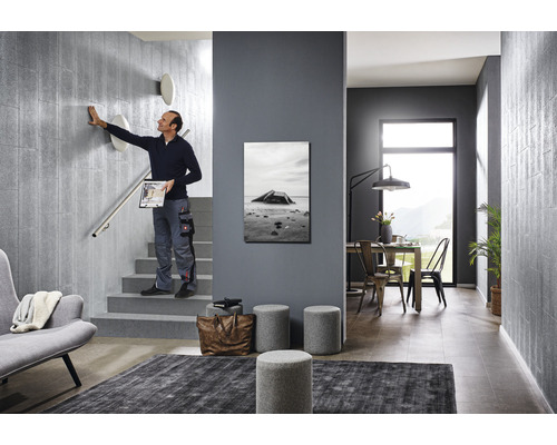 Scen av ett modernt designat trapphus med en person som rör en vägg, möbler och dekorationer