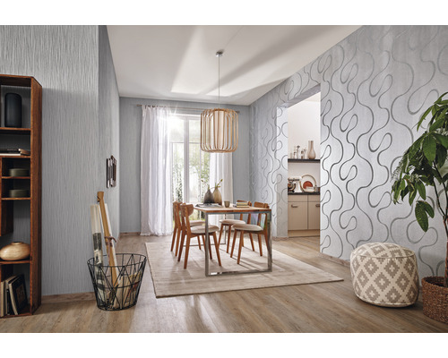 Modernt matrum med mönstrade tapeter, träbord och stolar.
