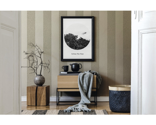 Vardagsrum med randig tapet, träskänk, dekoration och flätad korg