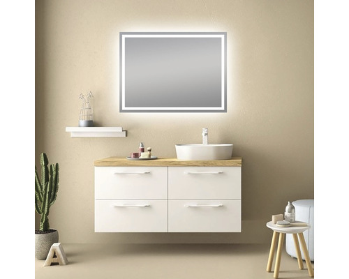 Badrum med tvättställsskåp, tvättställsskål och belyst spegel