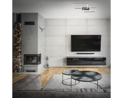 Vardagsrum med öppen spis, TV och geometrisk taklampa