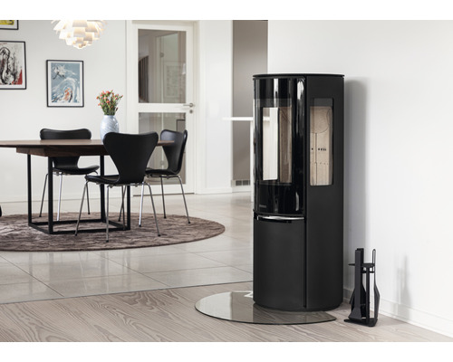 Vardagsrum med eldstad, matbord och stolar.