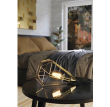 Dekorativ bordslampa med geometrisk design på ett nattduksbord i sovrummet.