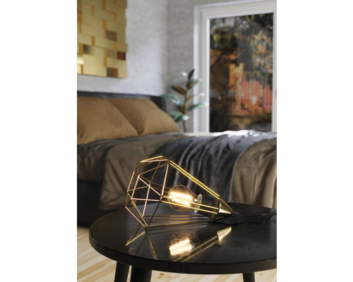 Dekorativ bordslampa med geometrisk design på ett nattduksbord i sovrummet.