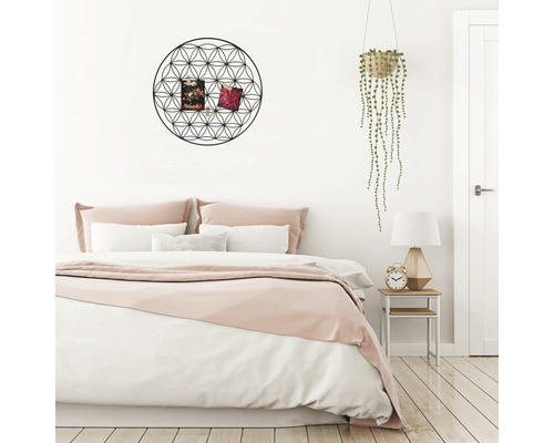 Sovrum med säng, sängbord, hängande växt och väggdekoration med geometriskt mönster