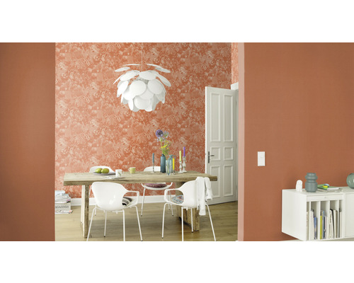 Vardagsrum med matbord, stolar, hänglampa och mönstrad tapet