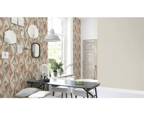 Matsal med geometrisk tapet, matbord och speglar på väggen.