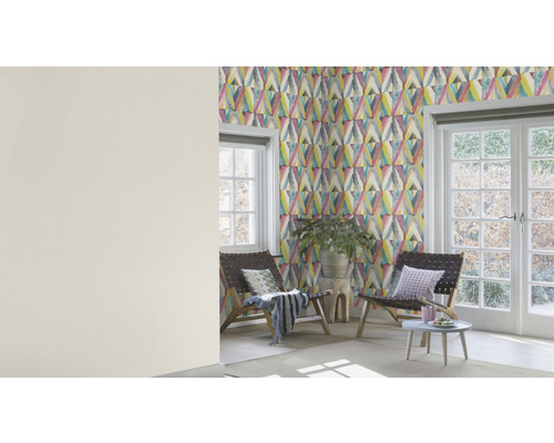 Ljust rum med mönstrad tapet, två stolar, ett sidobord och fönster