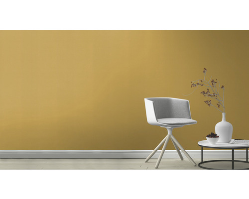 Scen med stol, sidobord med dekoration framför en vägg