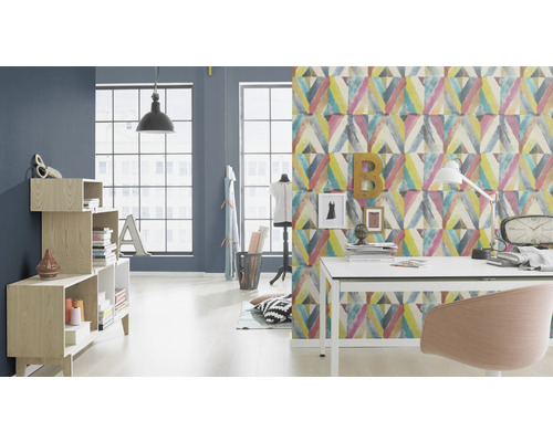 Vardagsrum med skrivbord, stol, hylla och mönstrad tapet