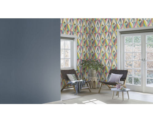 Vardagsrum med mönstrad tapet, två stolar och fönster mot trädgården