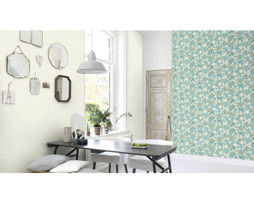 Matsal med blommig tapet, matbord och speglar på väggen.
