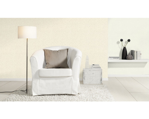 Ljust vardagsrum med fåtölj, golvlampa och mönstrad tapet