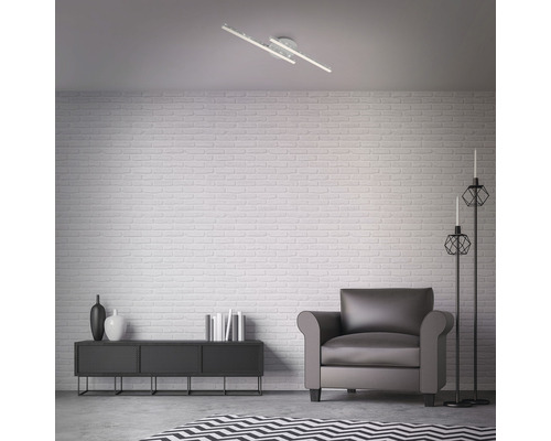 Vardagsrum med taklampa, fåtölj, byrå, golvlampor och matta