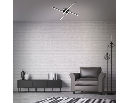 Modernt inrett vardagsrum med taklampa, fåtölj, skåp och dekoration