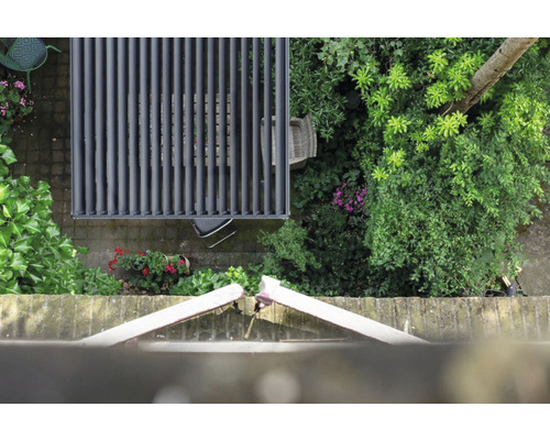 Översikt över en trädgård med ett terrasstak i aluminium och trädgårdsmöbler.