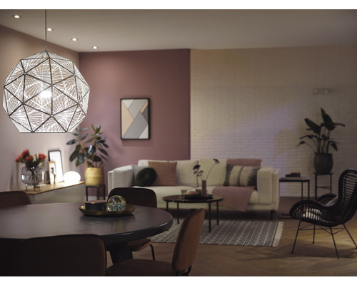 Vardagsrum med matbord, soffa och geometrisk pendellampa