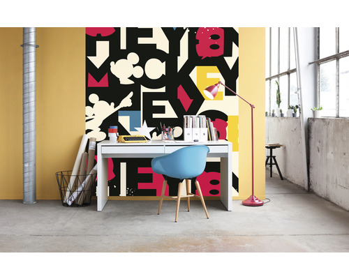 Ett rum med ett skrivbord, en stol och en tapet med ett bokstavsmönster