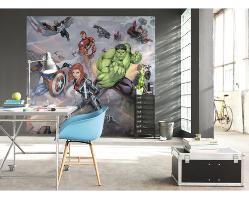 Ett rum med en fototapet med seriefigurer, ett skrivbord, en stol och en rullcontainer.