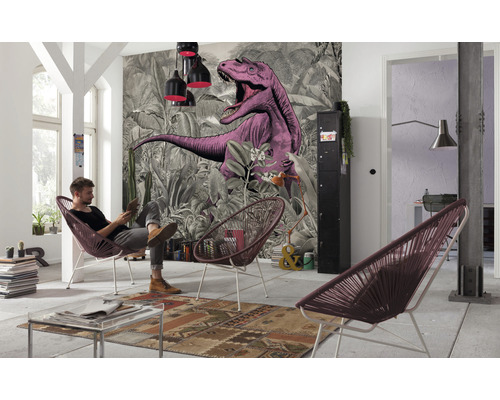 Vardagsrum med mönstrad tapet, taklampor och man i en stol